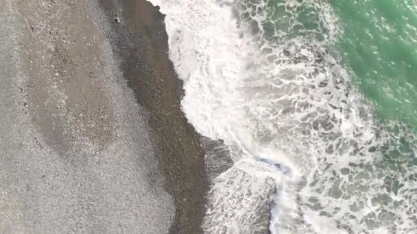 Un filmato aereo di un drone. Volare lungo la costa. Alesaggio mareale. Onde rotolare sopra la riva primo piano dall'alto e schiuma. — Video Stock