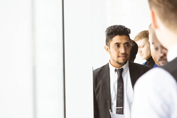 Retrato de un joven empresario con un traje en la oficina. Primer plano sentado en una silla junto a la ventana — Foto de Stock