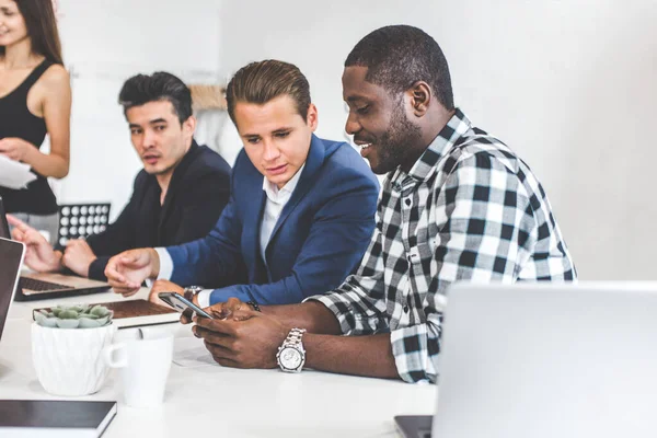 Un equipo de jóvenes trabajadores de oficina, empresarios con portátil trabajando en la mesa, comunicándose juntos en una oficina. Corporativosvapor y gerente en una reunión. coworking. — Foto de Stock