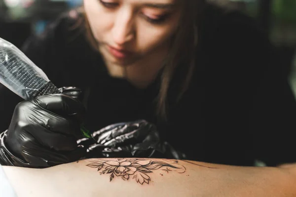 Woman tattoo artist doing tattoo in studio, making tattoo on body. closeup — Stock Photo, Image