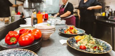 Oteldeki mutfak restoranında yemek pişiren profesyonel bir aşçı. Yemek hazırlıyor. Yemek servisi.
