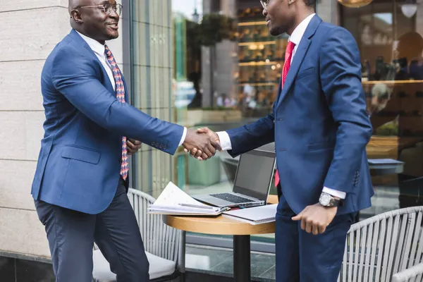 Retrato de dos hombres de negocios negros afroamericanos en trajes estrechando la mano al aire libre. La alegría de conocer buenos amigos — Foto de Stock