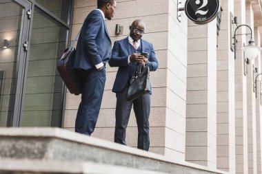 Dışarıdaki takım elbiseli iki siyahi Afro-Amerikan işadamının portresi..