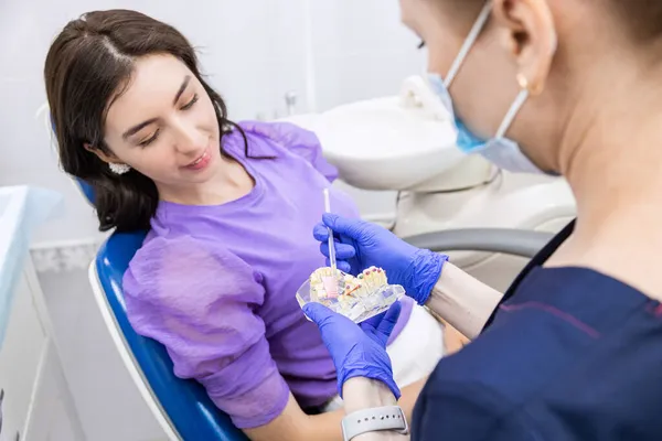 Conceito de Odontologia. Serviços odontológicos profissionais e equipamentos modernos sem dor. O médico demonstra ao paciente como escovar adequadamente os dentes — Fotografia de Stock