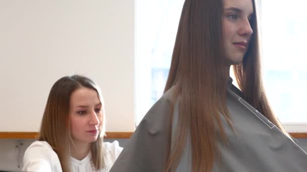 Nahaufnahme Friseur kämmt die Haare der Mädchen durch Styling in einem Schönheitssalon. — Stockvideo