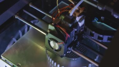 3D yazıcı yakın planda çalışıyor. Yüksek teknoloji, ısıtılmış polimer malzemeli plastik parçaların hızlı basımı. Makine modern bir prototip nesnesi oluşturur