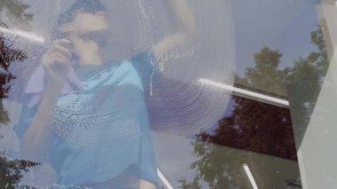 Profesyonel bir erkek işçi temizlik ve pencereleri temizlemekle meşgul. Temizlik servisi