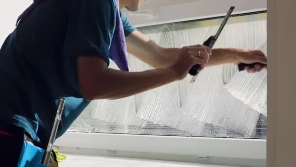 Профессиональный уборщик моет окна специальной пеной и моет их. — стоковое видео