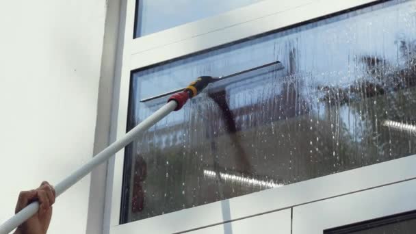 Profesionální mužský pracovník v montérkách se zabývá úklidem a mytím oken a vstupní halou — Stock video