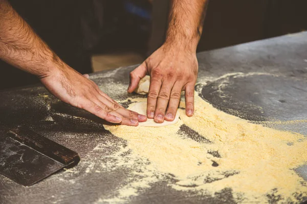 Professional chef cooking in the kitchen restaurant at the hotel, preparing dinner. A cook in an apron makes a pizza. — Stock Photo, Image