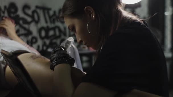 Επαγγελματική γυναίκα καλλιτέχνης τατουάζ κάνει ένα τατουάζ στο στούντιο, κοντινό πλάνο. — Αρχείο Βίντεο