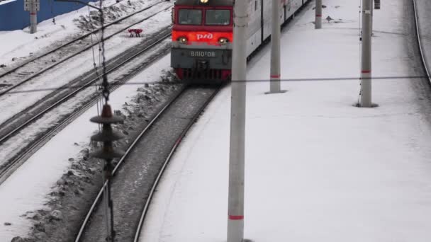 Ufa, Rússia, 16 de fevereiro de 2020: Uma locomotiva eletro-diesel puxa um trem de carga de muitos vagões através de uma grande junção ferroviária. Vista de cima. — Vídeo de Stock