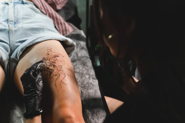 女性のタトゥーアーティストは、体にタトゥーを作る、スタジオで入れ墨をしています。閉鎖だ — ストック写真