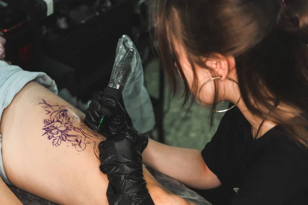 Donna tatuatrice che fa tatuaggi in studio, che fa tatuaggi sul corpo. primo piano — Foto Stock