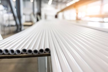 Polipropilen boru deposu. Plastik boru üretmek için ekstrakarların olduğu bir atölye. Su tedarik ve gaz borularından yüksek hızda ekstrüzyon hattı. Üretim tesisi.