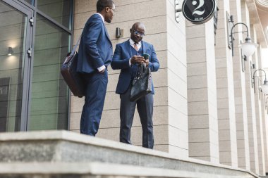 Açık havada takım elbiseli iki siyah Afrikalı Amerikalı iş adamı..