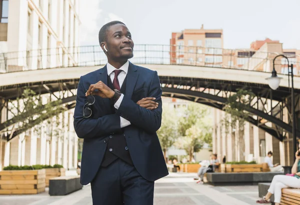 Retrato de hombre de negocios afroamericano negro en traje, gafas y auriculares al aire libre —  Fotos de Stock