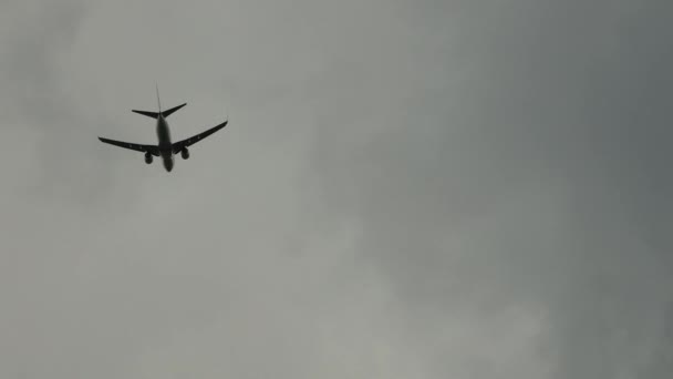 Um avião de passageiros a sobrevoar-nos prepara-se para aterrar num cenário de céu nublado. — Vídeo de Stock