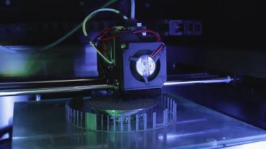3D yazıcı yakın planda çalışıyor. Yüksek teknoloji, ısıtılmış polimer malzemeli plastik parçaların hızlı basımı. Makine modern bir prototip nesnesi oluşturur