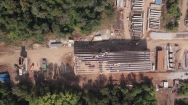 Nehir üzerinde bir köprü inşa edilmesinin en üst görüntüsü. Bir inşaat alanının insansız hava aracı, özel ekipman ve işçilerin yanı sıra köprü geçitlerinden ateş açıldı.