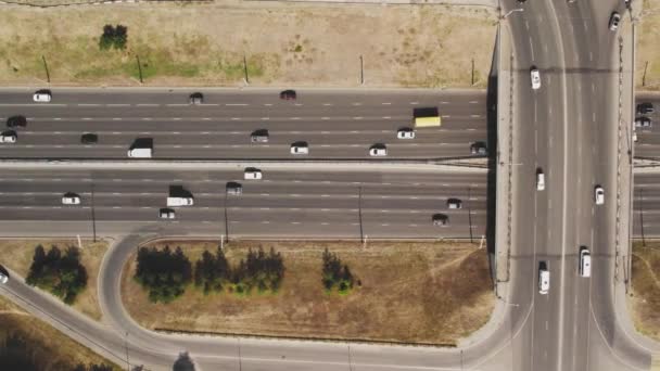 Pohled shora na silniční křižovatku. Letecký záznam z víceproudé silnice s jedoucími vozidly a štěrbinami cesty. Automobilová doprava ve velkém městě — Stock video