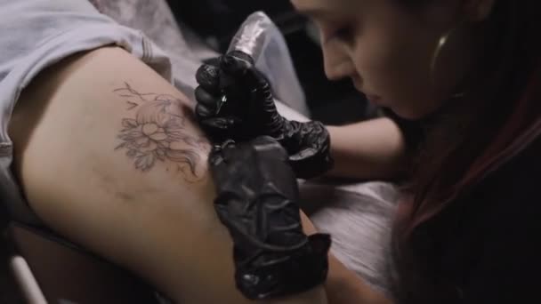 Mujer tatuadora haciendo tatuaje en el estudio, haciendo tatuaje en el cuerpo. primer plano — Vídeos de Stock