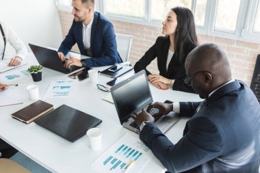 Çalışma masasında iş arkadaşlarıyla otururken çalışan ve iletişim kuran genç iş adamları. iş toplantısı