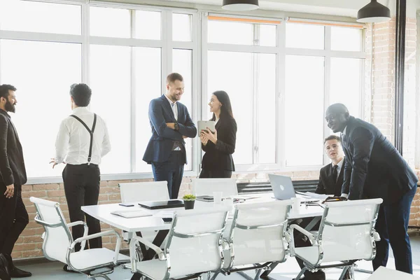 Siluetas de personas contra la ventana. Un equipo de jóvenes empresarios que trabajan y se comunican en una oficina. Corporativossteam y gerente en una reunión. — Foto de Stock