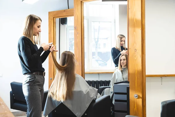 The master hairdresser cuts the ends of the hair after washing and in the beauty salon. — Stock Photo, Image