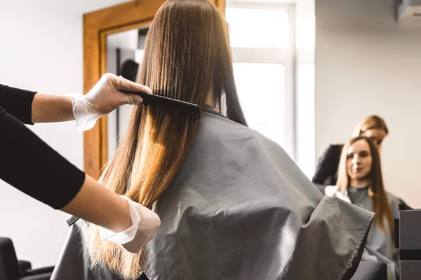Master fryzjer grzebień dziewczyny włosy po myciu i przed stylizacją w salonie piękności. — Zdjęcie stockowe
