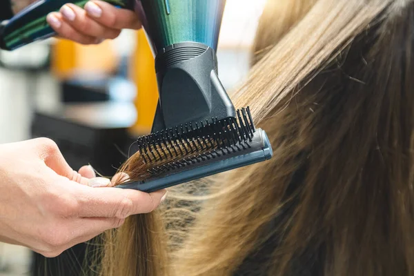 Maestra mujer peluquería seca el pelo de las niñas con un secador de pelo y peines después de lavarse en el salón de belleza — Foto de Stock