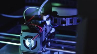 3D yazıcı yakın planda çalışıyor. Yüksek teknoloji, ısıtılmış polimer malzemeli plastik parçaların hızlı basımı. Makine modern bir prototip nesnesi oluşturur