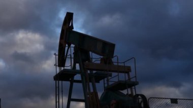 Enayi çubuğu pompaları çalışıyor ve akşam gökyüzünün zeminine yağ pompalıyor. Petrol kuyusu servisi