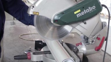 Ufa, Rusya, 30 Haziran 2020. Polipropilen üretim tesisi. Fabrika işçisi dairesel testere ile polipropilen boru kesiyor. Plastik boru üretmek için ekstrakarların olduğu bir atölye