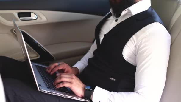 Indiase zakenman werken met laptop op de achterbank van de auto — Stockvideo