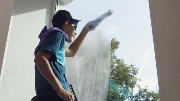 Profesjonalny pracownik firmy sprzątającej myje okna w firmach specjalnymi chemikaliami — Wideo stockowe