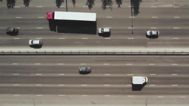 Utsikt från toppen till motorvägen. 4K flygdrönare fotografering av en flerfilig väg med rörliga fordon. Biltrafik i en storstad — Stockvideo