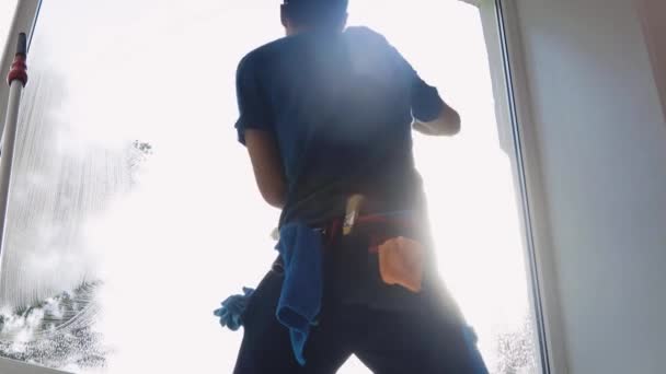 Um trabalhador de limpeza profissional lava as janelas com espuma especial e as limpa. — Vídeo de Stock