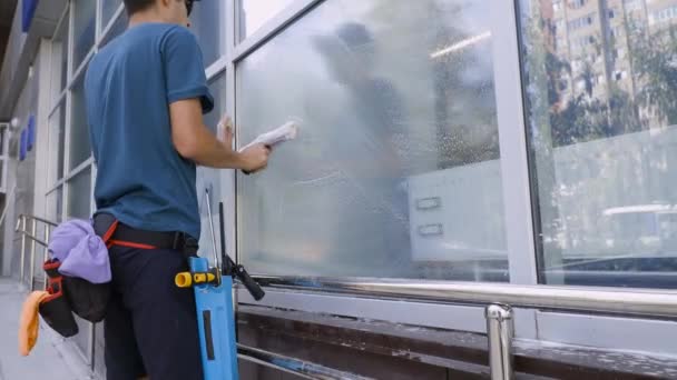 Filmagem 4K Limpeza profissional de janelas e lavagem de vidro close-up por um especialista em roupas de trabalho — Vídeo de Stock