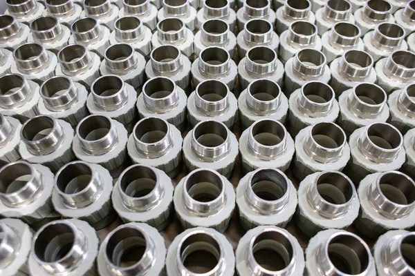 Veel metalen pijpkoppelingen in een pijpenfabriek — Stockfoto