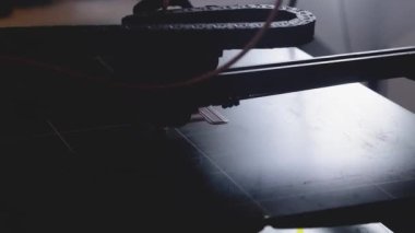 3D yazıcı yakın planda çalışıyor. Yüksek teknoloji, ısıtılmış polimer malzemeli plastik parçaların hızlı basımı. Makine modern bir prototip nesnesi oluşturur.