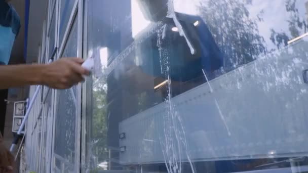 Filmagem 4K Limpeza profissional de janelas e lavagem de vidro close-up por um especialista em roupas de trabalho — Vídeo de Stock