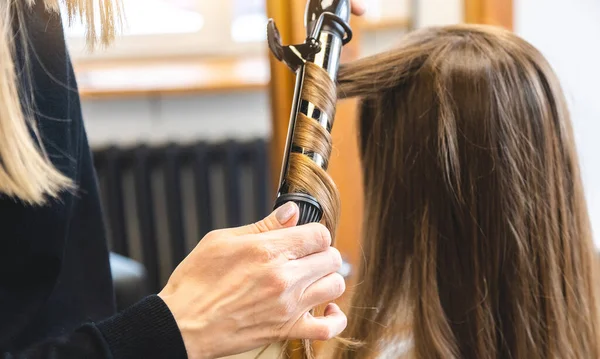 Master γυναίκα κομμώτρια απαλά μπούκλες μαλλιά κορίτσι μπούκλες σε ένα σαλόνι ομορφιάς. Κομμωτήριο — Φωτογραφία Αρχείου