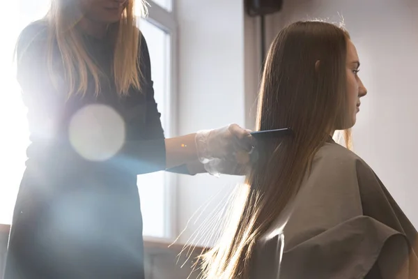 Master κομμωτήριο χτενίζει τα μαλλιά των κοριτσιών μετά το πλύσιμο και πριν από το στυλ σε ένα σαλόνι ομορφιάς. — Φωτογραφία Αρχείου