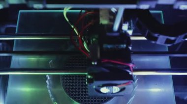 3D yazıcı yakın planda çalışıyor. Yüksek teknoloji, ısıtılmış polimer malzemeli plastik parçaların hızlı basımı. Makine modern bir prototip nesnesi oluşturur