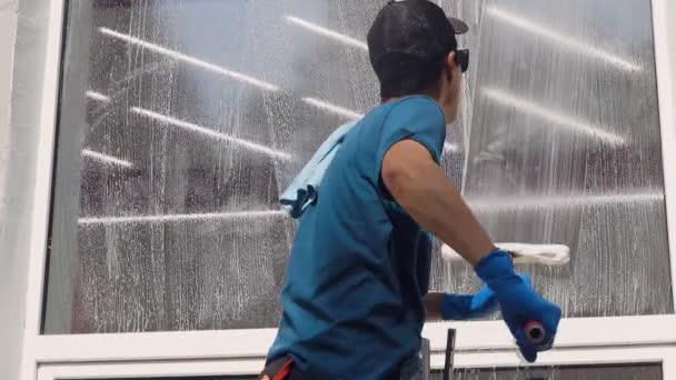 Profesyonel bir işçi camları özel ürünlerle temizler. Temizlik servisi — Stok video