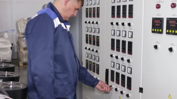 Male factory worker near the Electrical control room in industrial building Factory. Numeric indicators and buttons — Stock Video