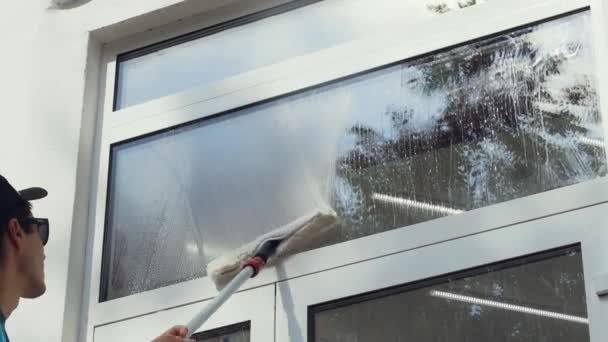 Профессиональный работник моет окна специальными продуктами. Услуги по уборке — стоковое видео