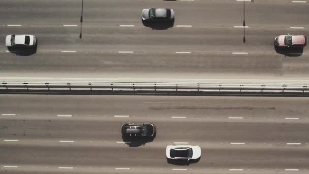 Utsikt från toppen till motorvägen. 4K flygdrönare fotografering av en flerfilig väg med rörliga fordon. Biltrafik i en storstad — Stockvideo