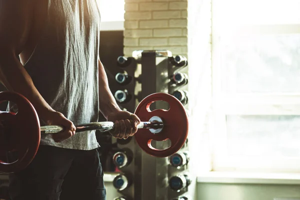 Gros plan des mains d'un homme musclé effectue des exercices avec un haltère dans la salle de gym. Entraînement de force d'endurance — Photo